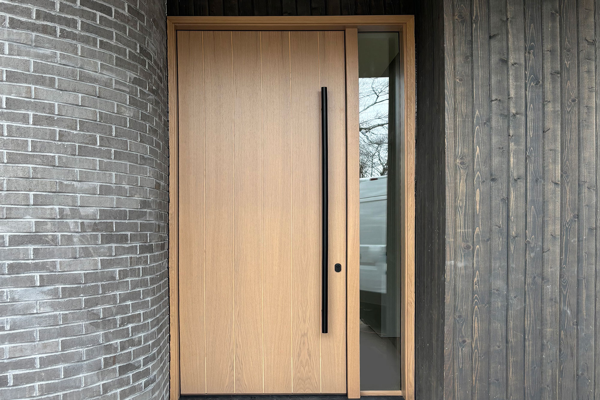 Luxury front entry door with double sidelights and decorative ironwork.